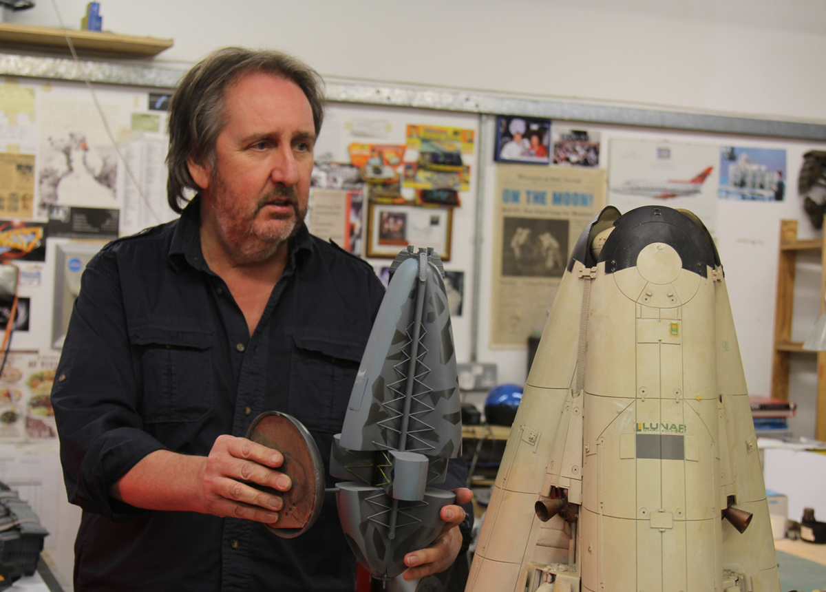 Bill Pearson demonstrates the idea behind the return craft from Moon alongside The Prop Gallerys original screen used miniature